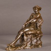 Alt text: Bronze sculpture of a nude woman sitting and reclining, angled view
