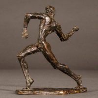 Alt text: Small bronze sculpture of an athlete caught in motion throwing with right arm, angled view