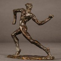 Alt text: Small bronze sculpture of an athlete caught in motion throwing with right arm, angled view