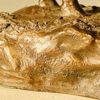 Alt text: Detail of grazing horse with inscription on base 