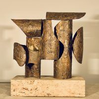 Alt text: Abstract bronze and steel assemblage mounted on a stone block, frontal view