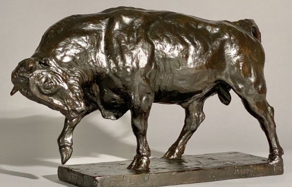 Alt text: Bronze sculpture of a bull preparing to charge, angled view