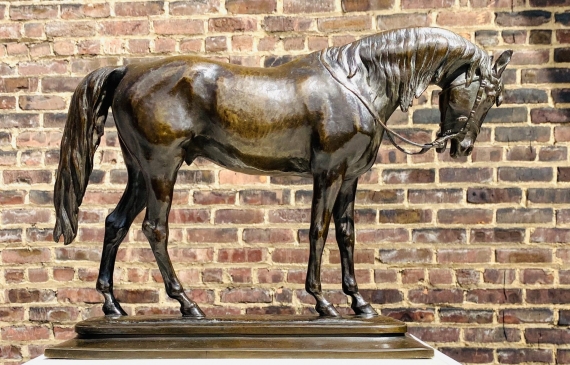 Alt text: Bronze sculpture of an Arabian horse with head slightly lowered, side view