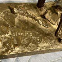 Alt text: Signature detail of a bronze sculpture of a horse