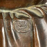 Alt text: Foundry mark detail of a bronze sculpture of a pensive woman