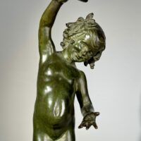 Alt text: Bronze sculpture of a child holding a seashell
