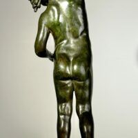 Alt text: Bronze sculpture of a child holding a seashell