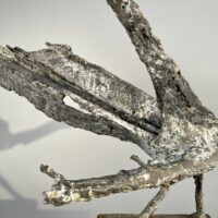 Alt text: Abstract bronze sculpture of a bird
