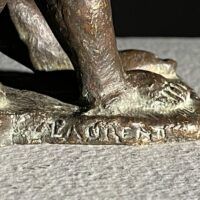 Alt text: Signature detail of a bronze sculpture of a reclining nude