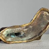 Alt text: Underside of a bronze sculpture of a reclining nude