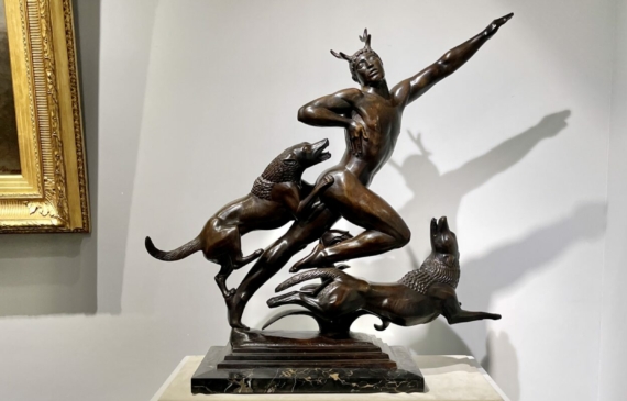 Bronze sculpture of man running with dogs