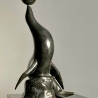 Alt text: Bronze sculpture of a seal with a ball