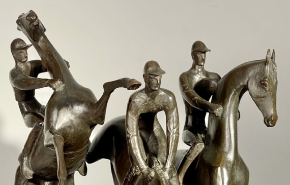 Alt text: bronze sculpture of three men on horseback