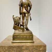 Alt text: Bronze sculpture of a man with a rifle