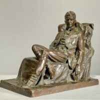 Alt text: Bronze sculpture of a seated man