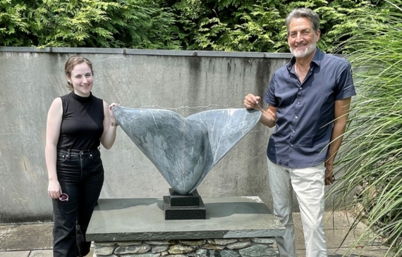 Alt text: two people standing outside with sculpture