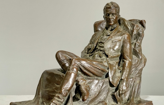 Alt text: Bronze sculpture of a seated man