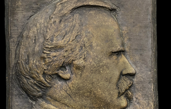 Alt text: Bronze bas relief of a man in profile