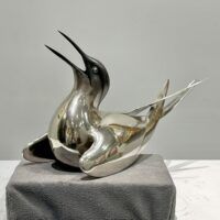 Alt text: Sculpture of a bird with a silver finish