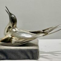 Alt text: Sculpture of a bird with a silver finish