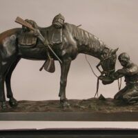 Alt text: Bronze sculpture of a figure kneeling in front of a horse